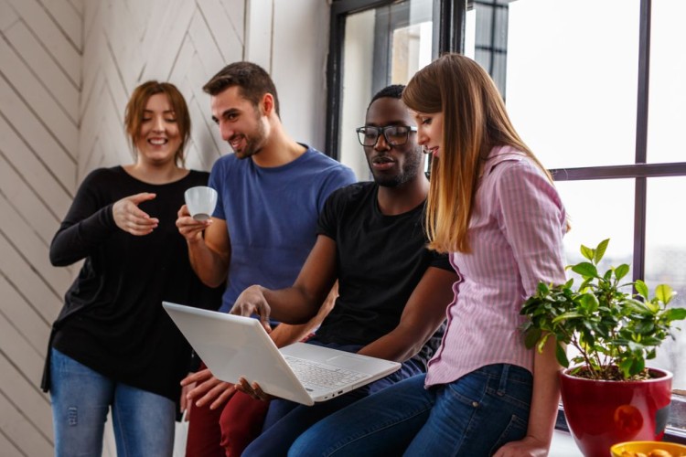 Gruppe von internationalen Studenten mit einem Laptop