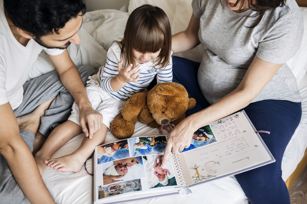 Familie blättert durch ein Fotoalbum